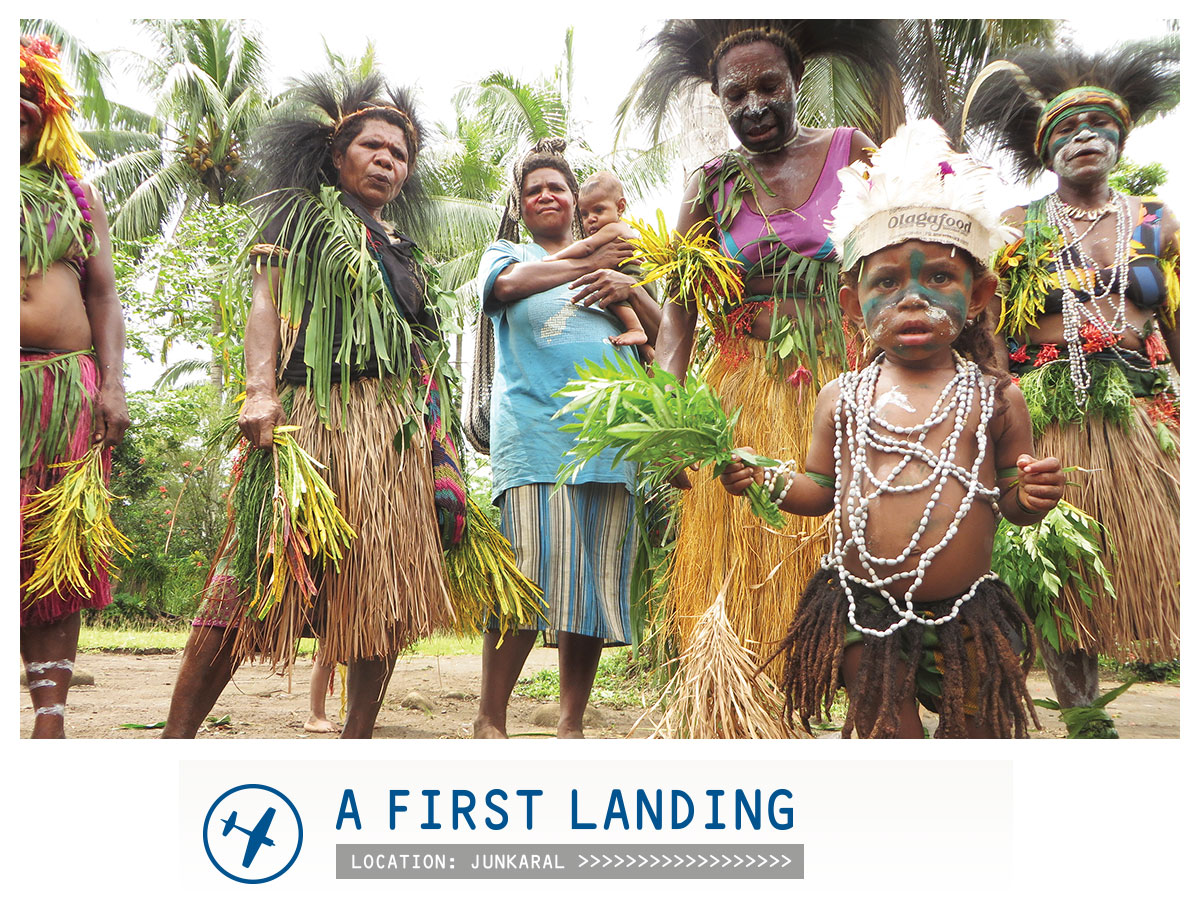 Picture of people in tribal dress with the caption "A first landing - location: Junkaral"